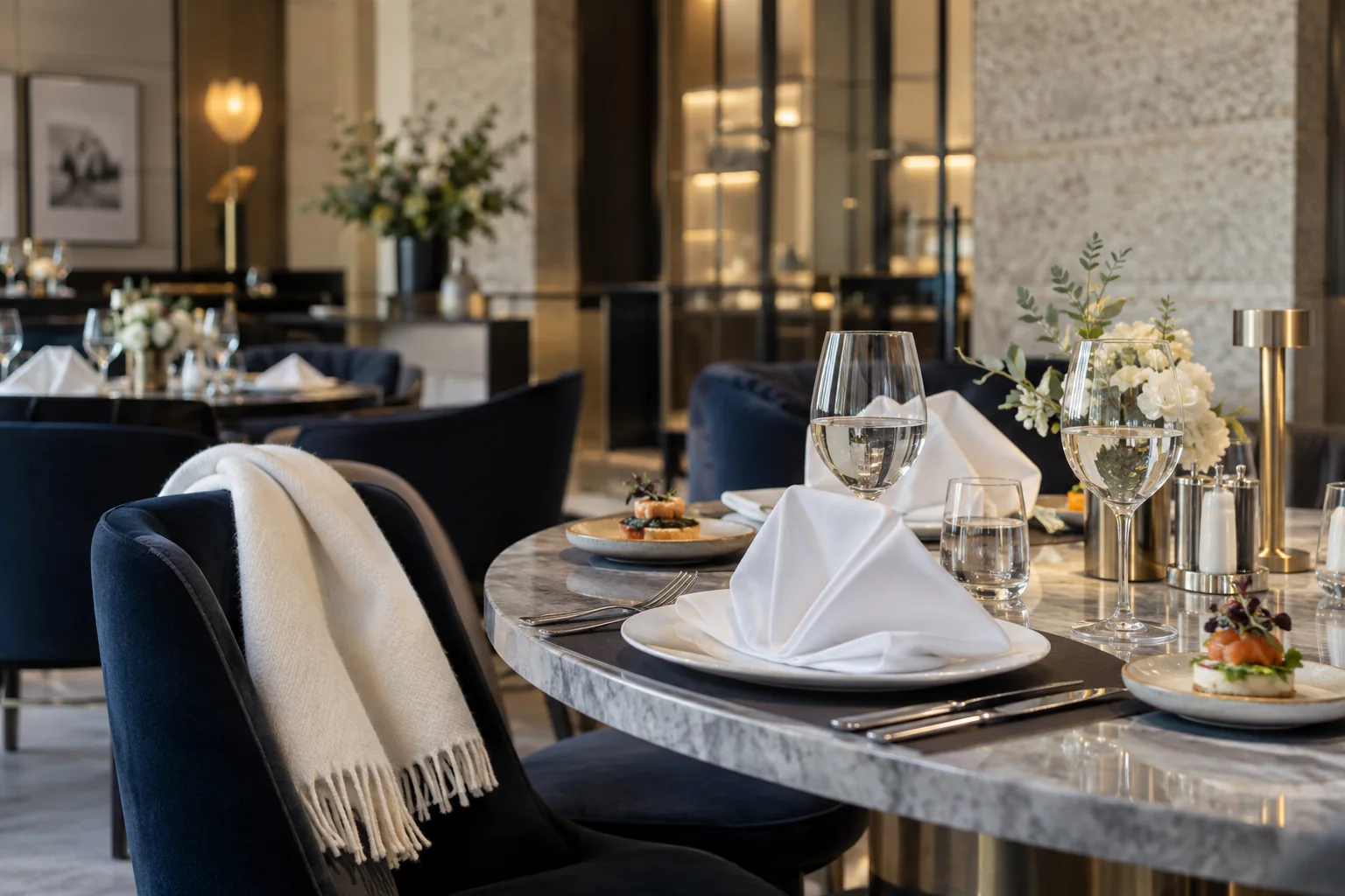 Mesa de hospitalidad con servilletas blancas, copas y pequeños aperitivos
